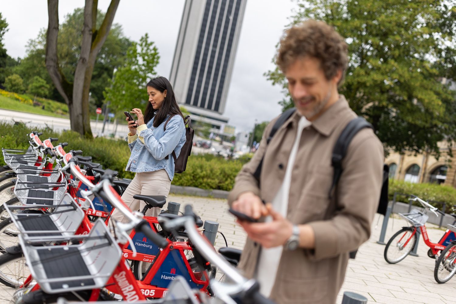Zwei Menschen stehen an einer StadtRAD-Station und laden sich die StadtRAD-App herunter